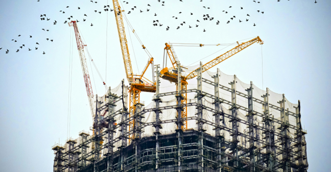 Baugerüst auf Großbaustelle mit vielen Kränen