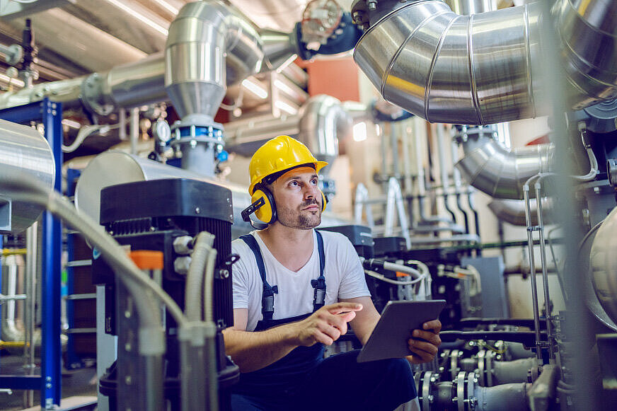 Arbeiter neben einem industriellen Gasmotor